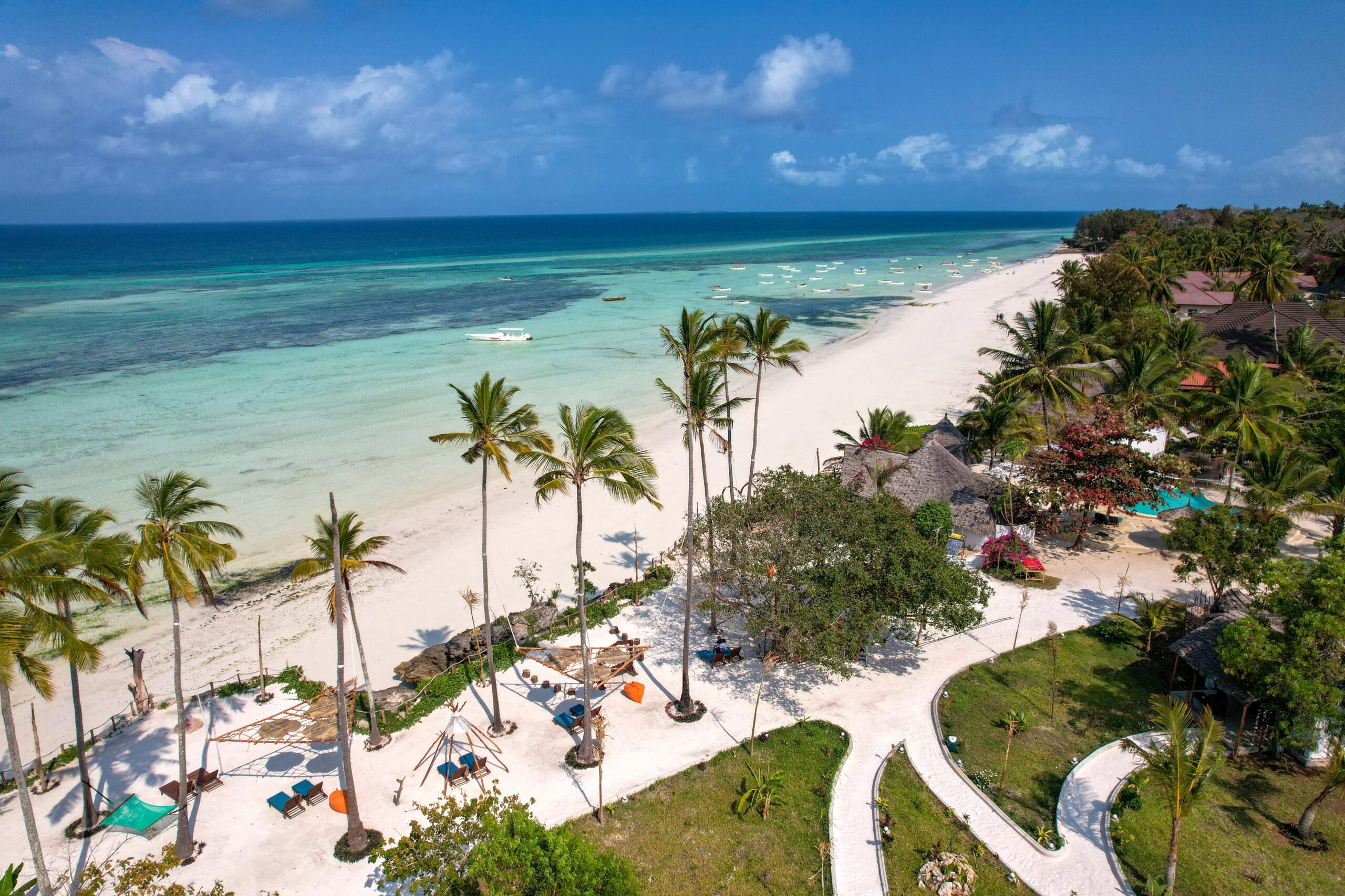 Discover the pristine beauty of a tropical beach resort in Zanzibar with turquoise waters and palm trees.