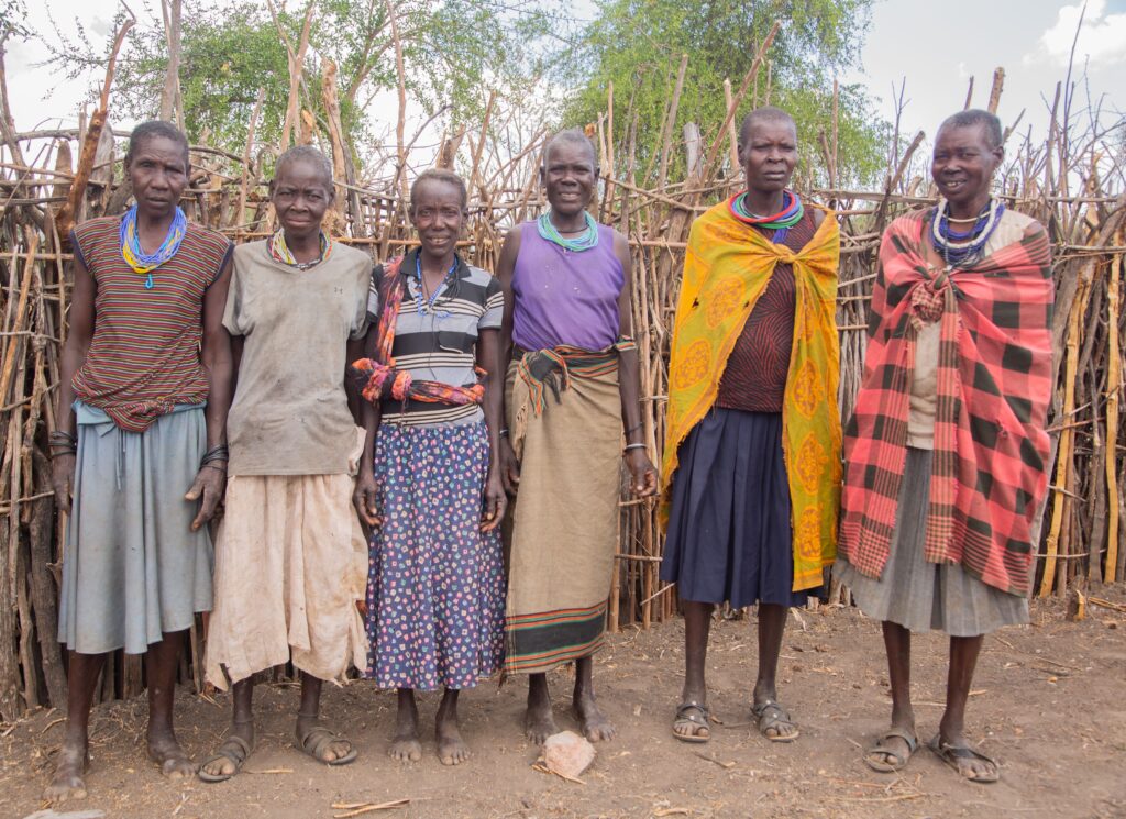 A group of Masai women in traditional clothing standing outdoors, showcasing tribal culture.