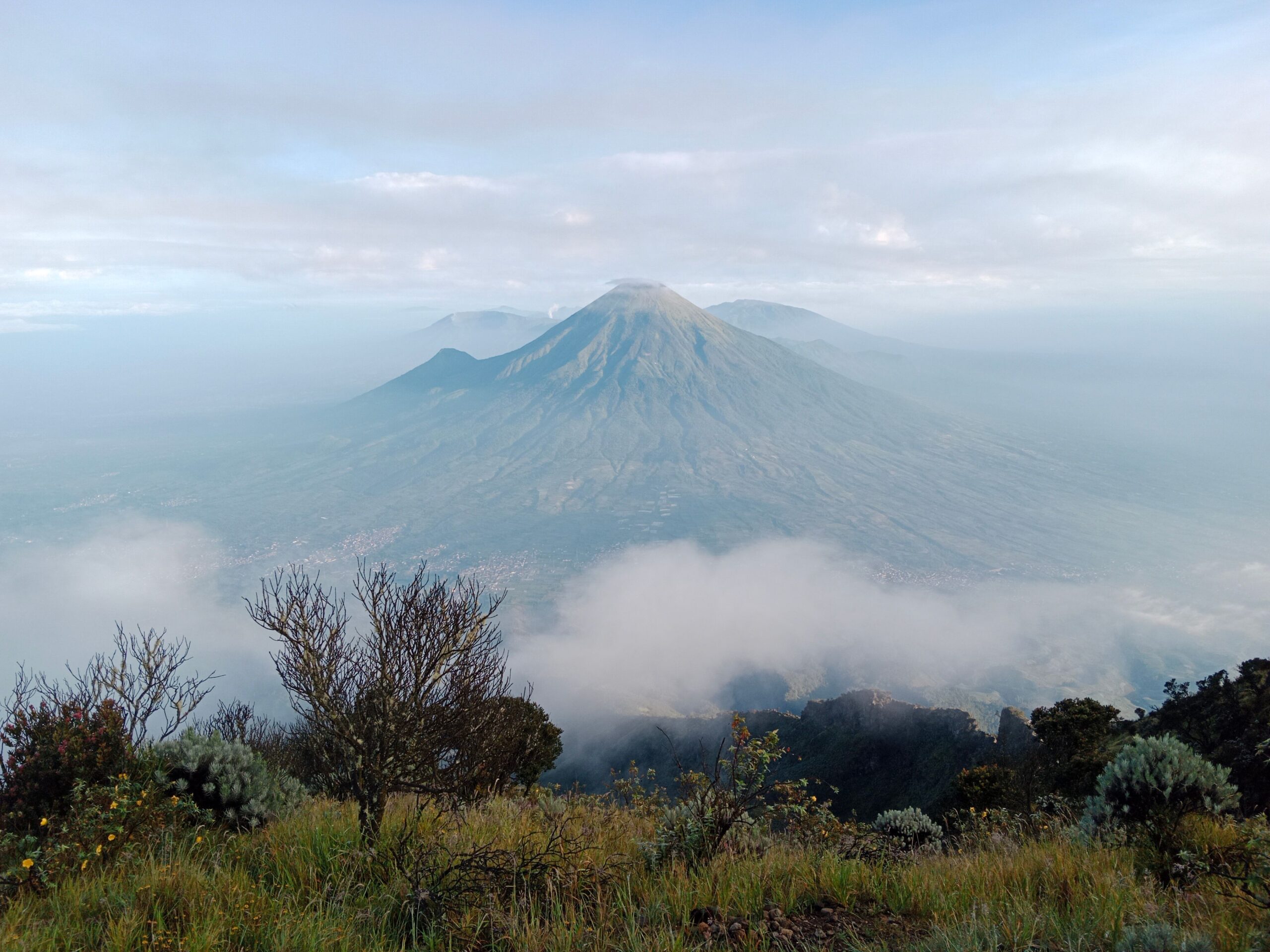 Scenic view of a majestic mountain surrounded by mist and clouds, capturing the serenity of nature.